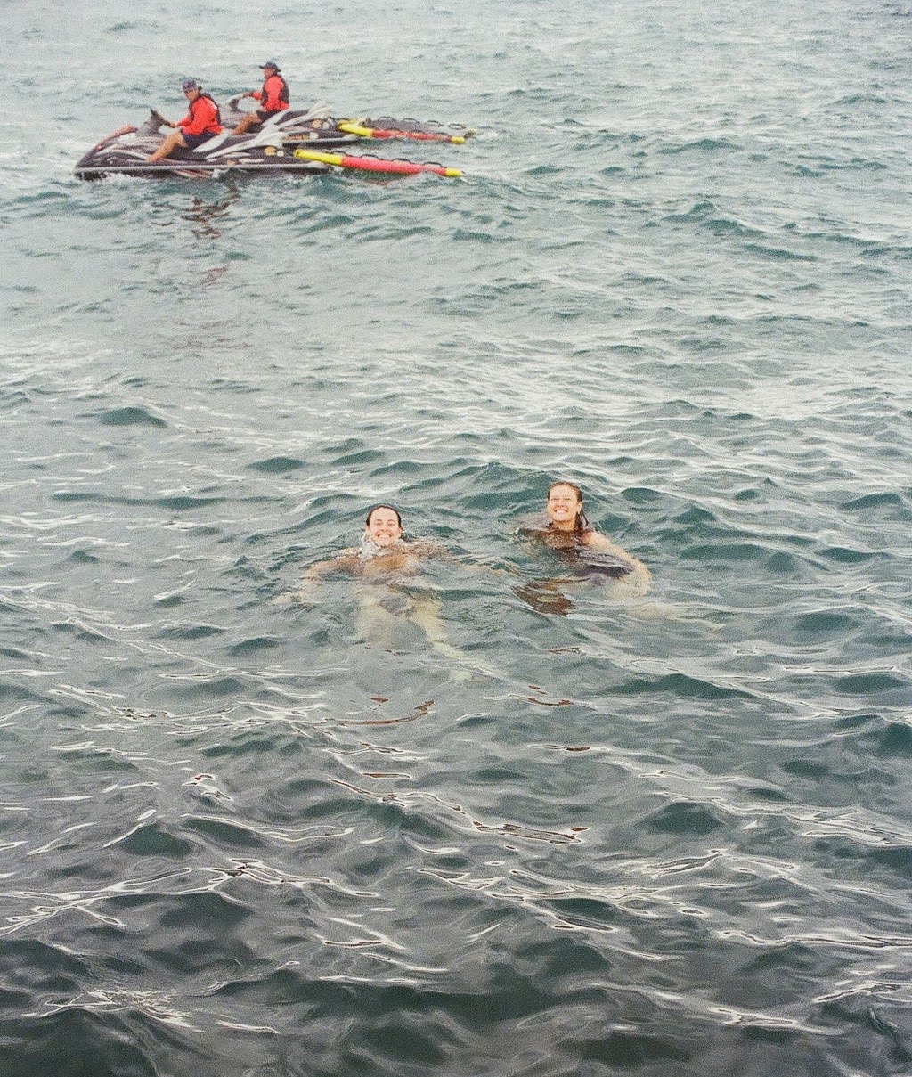Swimmers and a paddler in Lake Michigan