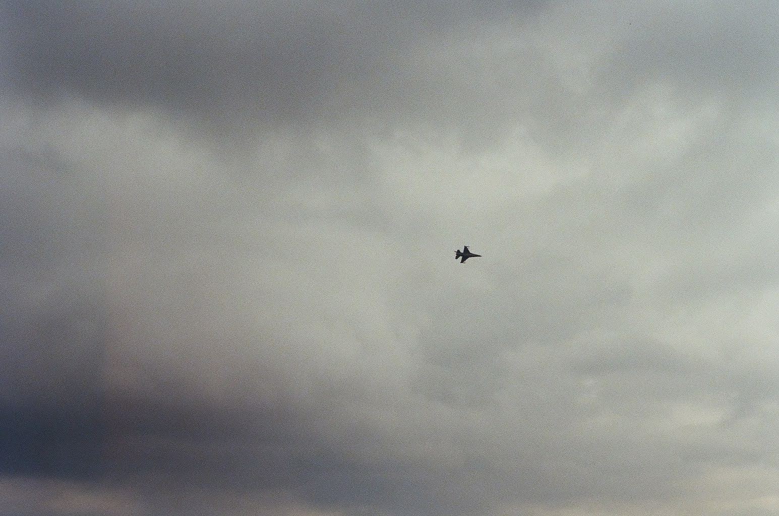 Airplane beneath dark clouds over Chicago
