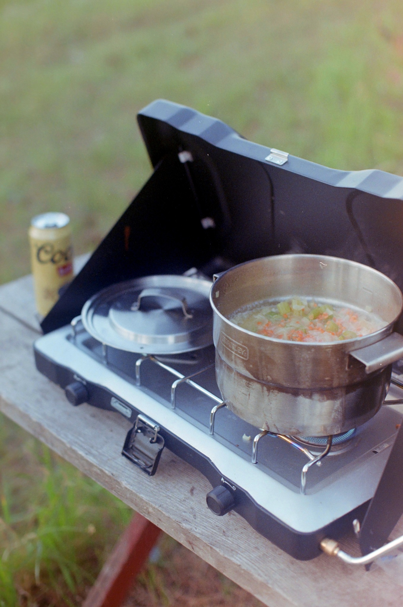 Camp stove with a pot cooking outdoors
