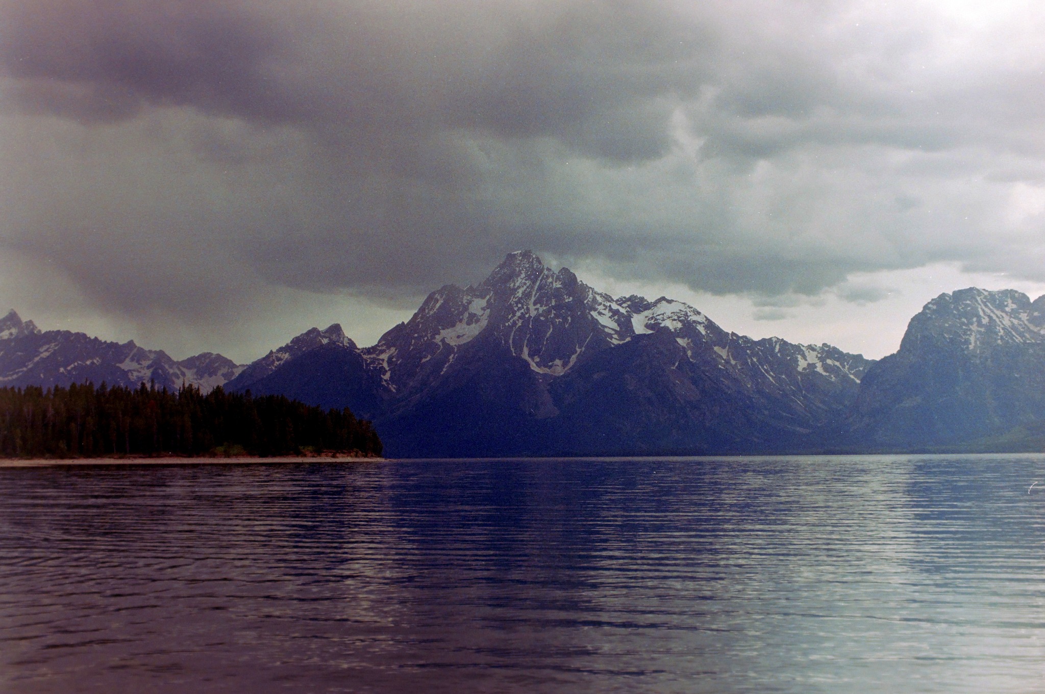 Storm clouds above the Tetons reflected across a lake